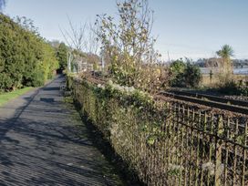 A path with a fence and benches beside railway tracks at Renes Shop in Grange-Over-Sands