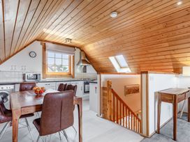 A kitchen with a dining table and chairs at Scandinavian Lodge 4 in Portreath