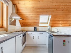 A kitchen with cabinets and appliances at Scandinavian Lodge 4 in Portreath