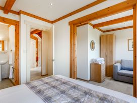 A bedroom with a bed and a sofa at Scandinavian Lodge 4 Portreath
