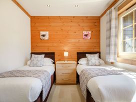 A bedroom with two single beds and a nightstand at Scandinavian Lodge 4 in Portreath