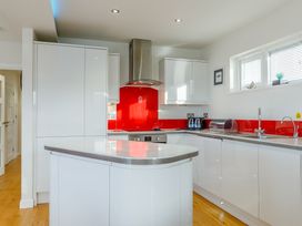 A kitchen with a red backsplash and modern appliances at Signature Lodge Pet 4 Portreath