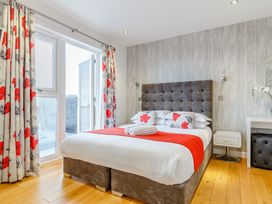 A bedroom with a bed and curtains at Signature Lodge Pet 4 in Portreath