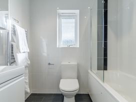 A bathroom with a toilet and bath tub at Signature Assisted Living 5 Portreath