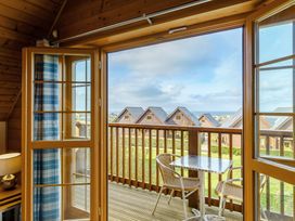 A balcony with a table and chairs at Scandinavian Hot Tub Lodge in Portreath