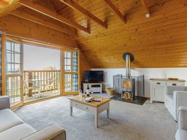 A living room with furniture and a balcony at Scandinavian Hot Tub Lodge in Portreath