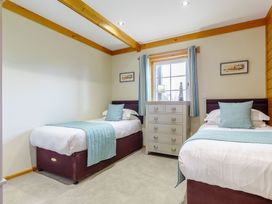 A bedroom with two beds and a dresser at Scandinavian Hot Tub Lodge Pet in Portreath