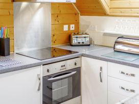 A kitchen with cooktop, oven, toaster and glassware at Scandinavian Lodge Pet in Portreath