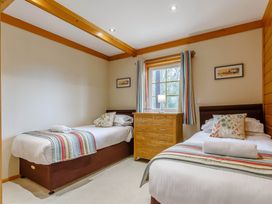 A bedroom with two beds and a dresser at Scandinavian Lodge Pet in Portreath