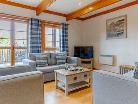 A living room with a sofa and television at Scandinavian Assisted Living in Portreath