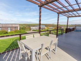 An outdoor patio with a table and chairs at Signature Lodge Pet 6 Portreath