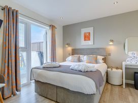 A bedroom with a bed and a mirror at Signature Lodge Pet 6 Portreath