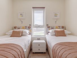 A bedroom with two beds and a window at Signature Lodge Pet 6, Portreath
