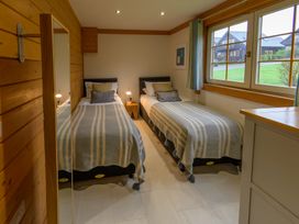 A bedroom with twin beds and a window at Senara Hot Tub Lodge (Pet) Portreath