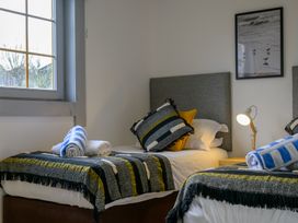 A bedroom with two beds and a lamp at Senara Hot Tub Lodge (Pet) Portreath