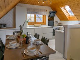 A kitchen with a dining table set in Senara Hot Tub Lodge (Pet) Portreath