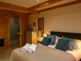 A bedroom with a bed and dresser at Senara Hot Tub Lodge (Pet) Portreath