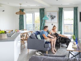A living room with a couple and a dog at Signature Lodge Pet 8, Portreath