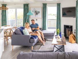 A living room with a sofa and a television at Signature Lodge Pet 8 in Portreath