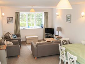 A living room with a sofa and dining table at 3 Moult Farm Cottages in Salcombe