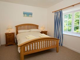 A bedroom with a bed and nightstand at 3 Moult Farm Cottages in Salcombe