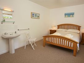 A bedroom with a double bed and a sink at 3 Moult Farm Cottages in Salcombe