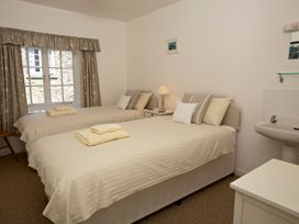 A bedroom with two beds and a sink at 3 Moult Farm Cottages in Salcombe