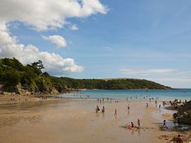 A beach with people enjoying the water at 3 Moult Farm Cottages in Salcombe