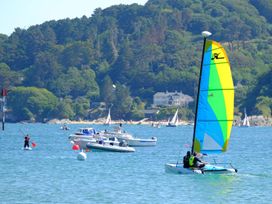 A sailboat and motorboats in water at 3 Moult Farm Cottages Salcombe