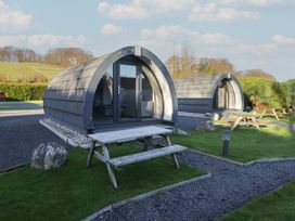 Two camping pods with seating areas at Pod 5 (Pet Friendly) Tewitfield