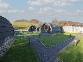 Three accommodation pods with a pathway and grass at Pod 5 (Pet Friendly) Tewitfield