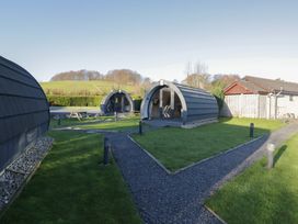 An outdoor area with glamping pods and a picnic table at Pod 7 (Pet Friendly) Tewitfield