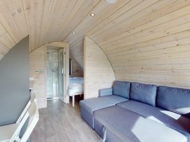 A bedroom with a sofa and a shower at Pod 8 (No Pets) Carnforth