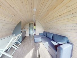 A living room with a sofa and a kitchen unit at Pod 8 (No Pets) Carnforth