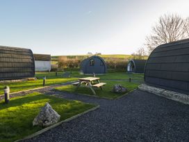 An outdoor area with cabins and a picnic table at Pod 9 (No Pets) Tewitfield near Carnforth