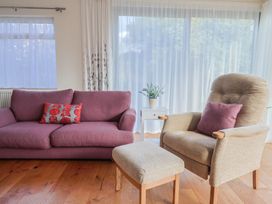 A living room with a sofa an armchair and a coffee table at Fluta in Seaton