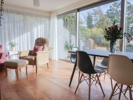 A living room with a chair and dining table at Fluta in Seaton