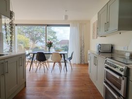 A kitchen with a dining table and chairs at Fluta in Seaton