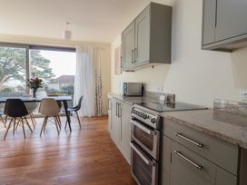 A kitchen with a stove and table at Fluta in Seaton