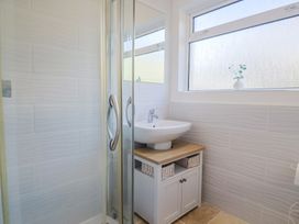 A bathroom featuring a shower, sink and storage at Fluta in Seaton