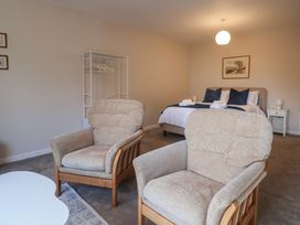 A bedroom with armchairs and a bed at Fluta in Seaton