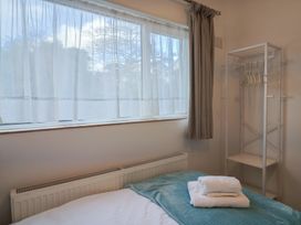 A bedroom with a bed and clothes rack at Fluta in Seaton