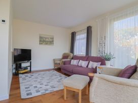 A living room with a sofa and television at Fluta in Seaton
