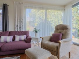 A living room with a sofa, chair, and plant at Fluta in Seaton