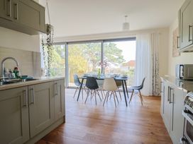 A kitchen with a dining area and glass doors at Fluta in Seaton