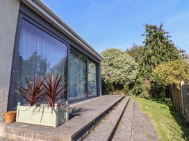 A garden with steps leading to glass doors at Fluta in Seaton