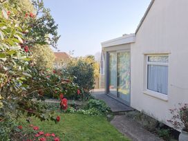 An outdoor area with flowering plants and a glass door at Fluta in Seaton