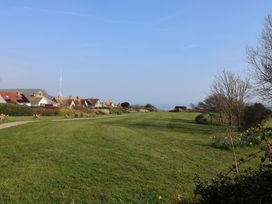 A view of a grassy area with houses and ocean at Fluta Seaton