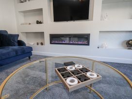 A living room with a sofa, coffee table and television in 2 bed Scarborough