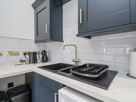 A kitchen with a sink, kettle, and coffee maker at 2 bed in Scarborough